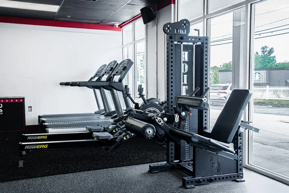 Treadmills, Concept2 RowErgs and the Bolt leg machine by the front windows at Atlas Fit